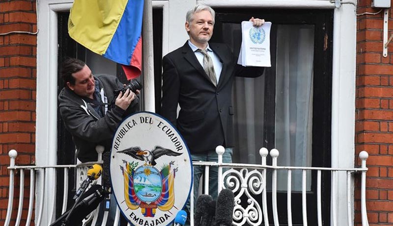 WikiLeaks founder Julian Assange addresses the media holding a printed report of the judgement of the UN s Working Group on Arbitrary Detention on his case from the balcony of the Ecuadorian embassy in central London on February 5  2016  During a press conference on February 5 Julian Assange  speaking via video-link  called for Britain and Sweden to  implement  a UN panel finding saying that he should be able to walk free from Ecuador s embassy  where he has lived in self-imposed confinement since 2012    AFP   BEN STANSALL
