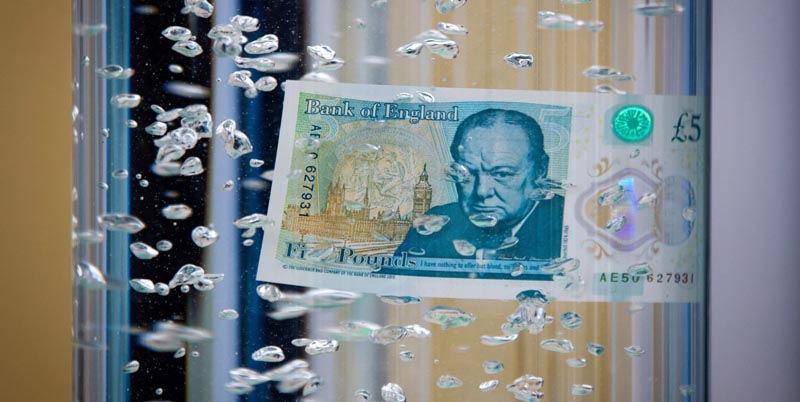 SIM01 WOODSTOCK (REINO UNIDO) 02/06/2016.- Vista general del nuevo billete de cinco libras esterlinas sumergido en un recipiente con agua durante su presentación en el palacio de Blenheim en Oxfordshire, Reino Unido hoy, 2 de junio de 2016. El Banco de Inglaterra desveló hoy el diseño de su nuevo billete de cinco libras esterlinas (6,45 euros), el primero fabricado con plástico en el Reino Unido, que entrará en circulación en próximo 13 de septiembre. EFE/Simon Dawson /POOL