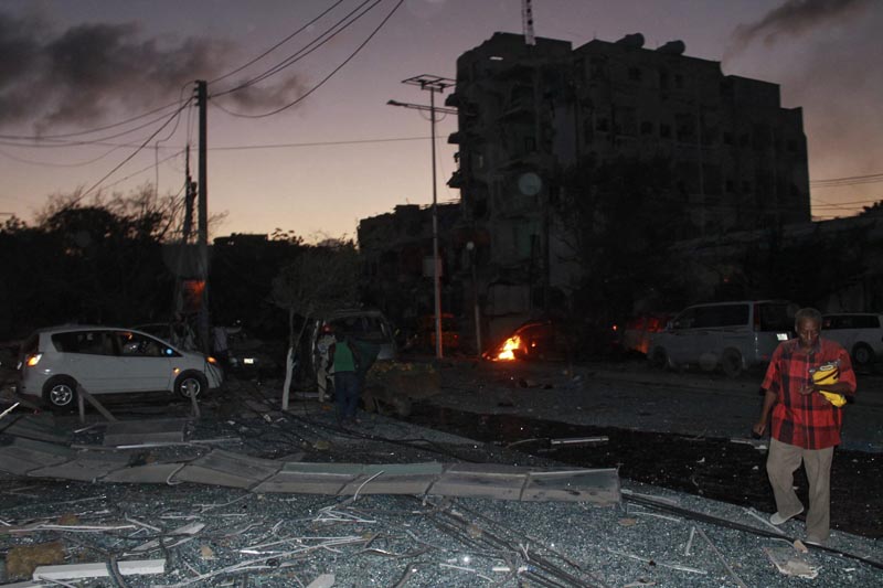 DAI02 MOGADISCIO (SOMALIA), 01/06/2016.- Varias personas en el lugar del atentado tras el ataque con coche bomba contra un céntrico hotel de la capital en Mogasdiscio, Somalia, hoy 1 de junio de 2016. Al menos 7 personas han muerto y 17 han resultado heridas en el popular Hotel Ambassador, donde se registró una gran explosión producida por un coche bomba, antes de que un grupo de cinco yihadistas irrumpieran en sus instalaciones. EFE/Said Yusuf Warsame