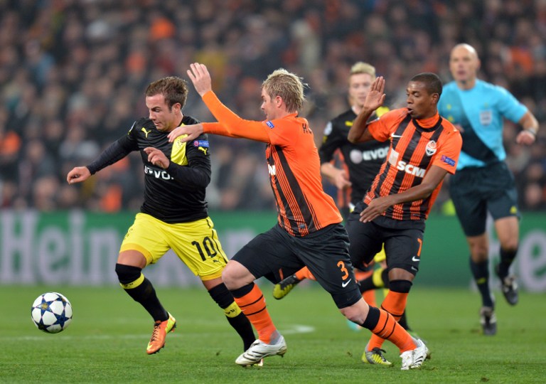 Tomas Hubschman  (2L) of  FC Shakhtar fights for a ball with Mario Goetze  (L) of Borussia Dortmund during their UEFA Champions League round 16 football match in Donetsk on February 13, 2013. AFP PHOTO/ SERGEI SUPINSKY / AFP PHOTO / SERGEI SUPINSKY