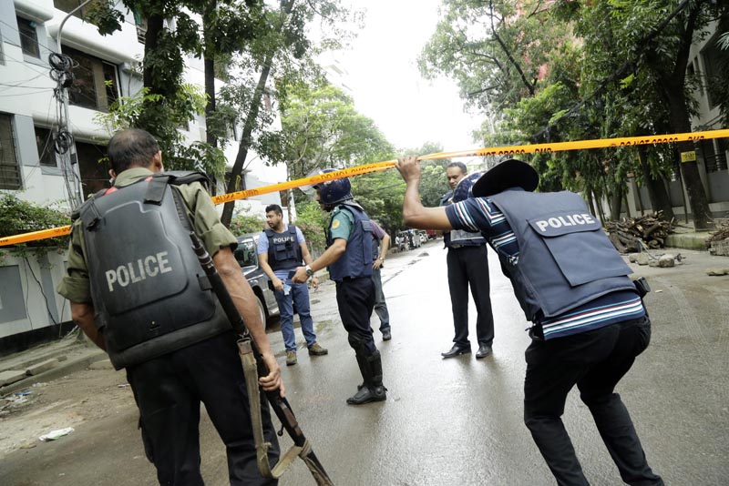 AAA12. Dhaka (Bangladesh), 02/07/2016.- Policemen behind tape to resrict media and others in the streets close to the Holey Artisan Bakery in Dhaka, Bangladesh 02 July 2016. Six gunmen have been shot and killed during an operation to end a hostage situation by military commandos, while two policemen were killed by the gunmen earlier and more than 20 people were injured. EFE/EPA/STRINGER