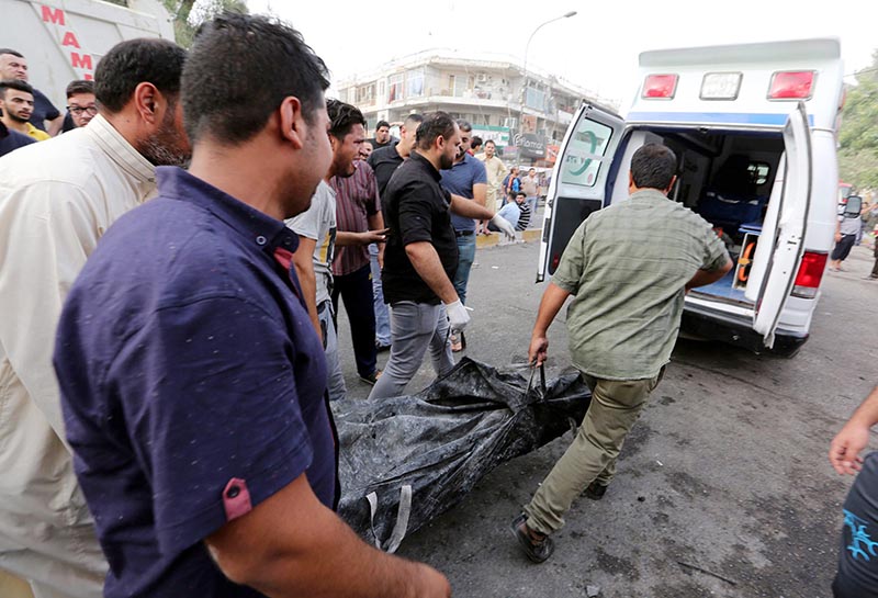 EBAG09. Baghdad (Iraq), 03/07/2016.- Iraqi rescue workers remove the body of a victim who was killed by a suicide attack in the Karada district of central Baghdad, Iraq, 03 July 2016. At least 23 people were killed and 70 others were wounded in a suicide car bomb attack targeted Karada district of Baghdad and other attack by a roadside bomb in Shaab market , Iraqi police said. (Atentado, Bagdad) EFE/EPA/ALI ABBAS