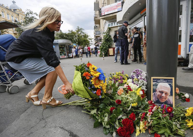 RPI01 KIEV (UCRANIA) 20/07/2016.- Una mujer deposita flores en el lugar donde el periodista Pável Sheremet fue asesinado al estallar una bomba en el vehículo que conducía en el centro de Kiev, Ucrania hoy, 20 de julio de 2016. La explosión se produjo sobre las 07.45 hora local (04.45 GMT) en la intersección de las calles Bogdan Jmelnitski e Iván Frankó, minutos después de que el periodista abandonara su domicilio. Sheremet, de 44 años, nació en Minsk pero tenía nacionalidad rusa, era un conocido periodista con una destacada trayectoria profesional en Bielorrusia y Rusia, y se hallaba radicado en Kiev desde hace cinco años. EFE/Roman Pilipey