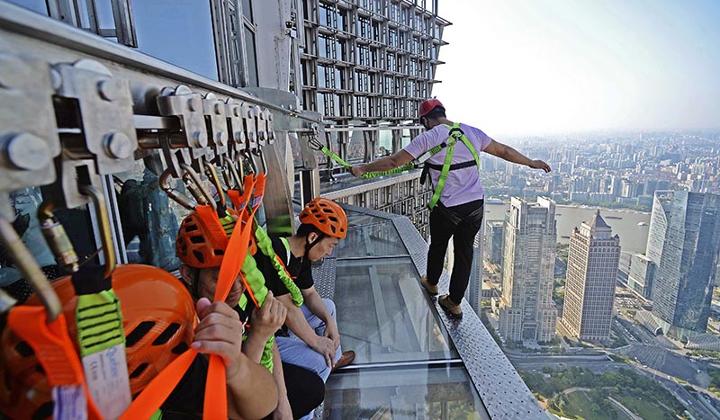 CH01. SHANGHÁI (CHINA), 28/07/2016.- Fotografía disponible hoy, viernes 29 de julio de 2016, de personas caminando sobre una pasarela acristalada en el piso 88 de la Torre Jinmao en Shanghái (China). La pasarela está abierta a los turistas, quienes pueden caminar ayudados de cuerdas de seguridad. EFE/XI LI/PROHIBIDO SU USO EN CHINA