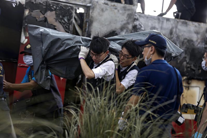 TAI30 TAOYUAN (TAIWAN) 19/07/2016.- Dos investigadores trasladan el cuerpo de un fallecido en el accidente de un autobús cerca del aeropuerto Internacional de Taoyuan, a las afueras de Taipei, Taiwán, hoy, 19 de julio de 2016. Al menos 26 pasajeros de un autobús que trasladaba turistas chinos han muerto al chocar el vehículo con la barrera externa de la carretera que conduce al aeropuerto de Taoyuan, e incendiarse después, según informó hoy la Dirección General de Bomberos de Taiwán. Aún no se ha establecido la causa del incendio, tan sólo se sabe que el autobús chocó contra una valla protectora y se incendió con rapidez, estallando después, según afirmaron testigos del suceso. EFE/Ritchie B. Tongo