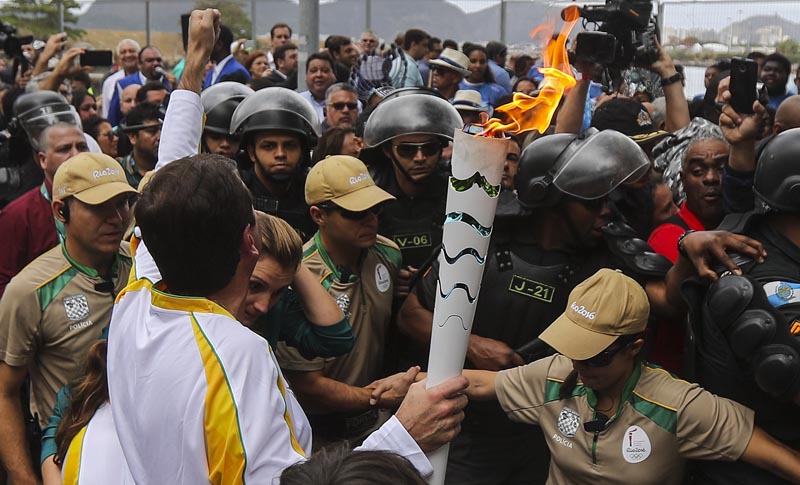 BRA01. RÍO DE JANEIRO (BRASIL), 03/08/16.- El alcalde de Río de Janeiro, Eduardo Paes (i), recibe la antorcha olímpica hoy, miércoles 3 de agosto de 2016, a su llegada en la ciudad de Río de Janeiro (Brasil), sede de los Juegos Olímpicos que empiezan el viernes 5 de agosto. EFE/ Antonio Lacerda