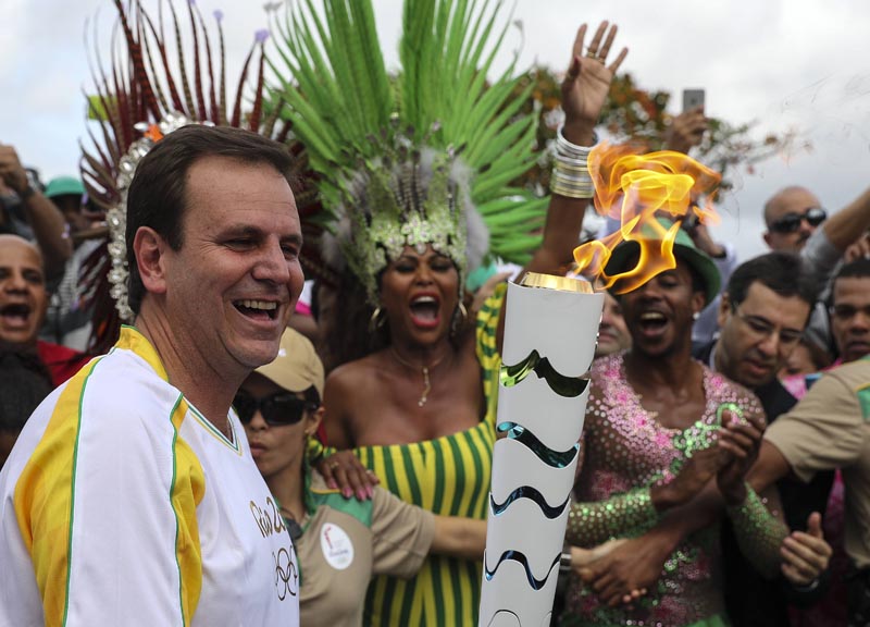 BRA01. RÍO DE JANEIRO (BRASIL), 03/08/16.- El alcalde de Río de Janeiro, Eduardo Paes (i), recibe la antorcha olímpica hoy, miércoles 3 de agosto de 2016, a su llegada en la ciudad de Río de Janeiro (Brasil), sede de los Juegos Olímpicos que empiezan el viernes 5 de agosto. EFE/ Antonio Lacerda