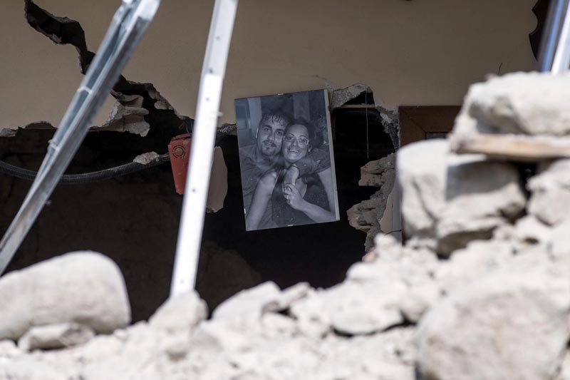 ITA48 FONTE DEL CAMPO (ITALIA), 24/08/2016.- Vista de la foto de una pareja entre los escombros de una casa tras el terremoto en la localidad de Fonte del Campo, cerca de Accumoli en el centro de Italia, hoy, 24 de agosto de 2016. Al menos 62 personas han muerto y decenas siguen aún desaparecidas tras el terremoto de 6 grados en la escala Ritcher ocurrido hoy en el centro de Italia, según los datos recogidos por los medios de comunicación italianos que se encuentran en los lugares afectados. EFE/Angelo Carconi