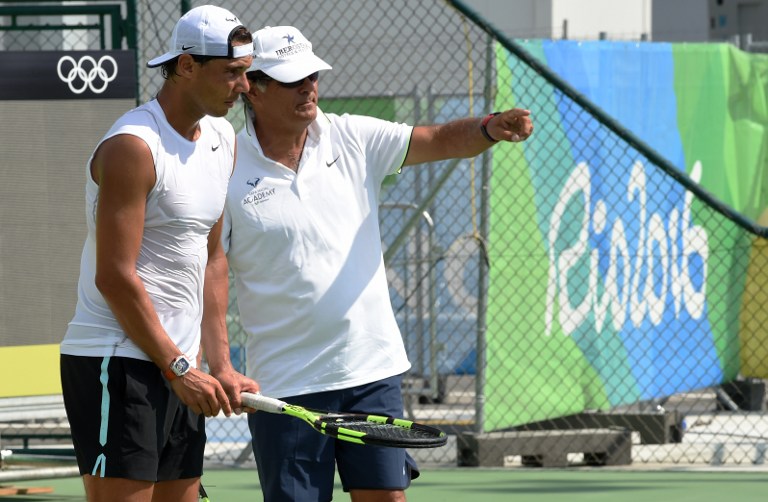 Rafael Nadal of Spain (L) listens to his coach and uncle, Toni Nadal during a practice session at the Olympic Tennis Center in Rio de Janeiro on August 2, 2016, ahead of the Rio 2016 Olympic Games.  / AFP PHOTO / ROBERTO SCHMIDT