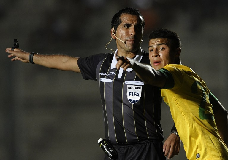 Bolivian referee Raul Orosco (L) and Brazilian Rafael Alcantara gesture during their South American U-20 Championship Group B football match against Venezuela, at Bicentenario stadium in San Juan, Argentina, on January 16, 2013. Four South American teams will qualify for the FIFA U-20 World Cup Turkey 2013.  Brazil won by 1-0.  AFP PHOTO / ALEJANDRO PAGNI / AFP PHOTO / ALEJANDRO PAGNI