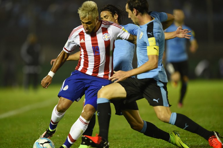 Paraguay's forward Dario Lezcano (L) is marked by Uruguay's Diego Godin during their Russia 2018 World Cup football qualifier match in Montevideo, on September 6, 2016. / AFP PHOTO / MIGUEL ROJO