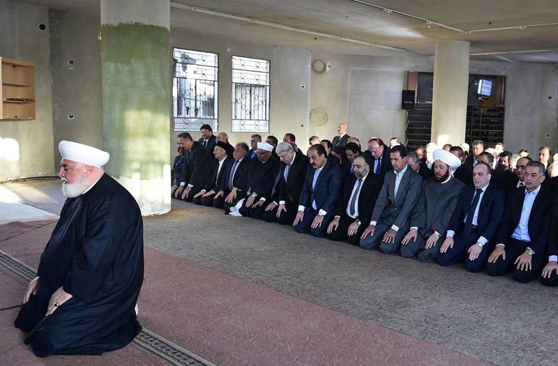 A handout picture released on the Syrian Presidency Facebook page on September 12, 2016, shows Syrian President Bashar al-Assad (4th from R) performing the morning prayer of the Muslim holiday of the Eid al-Adha at a mosque in a government-controlled area of Daraya. / AFP PHOTO / Syrian Presidency Facebook page / - / RESTRICTED TO EDITORIAL USE - MANDATORY CREDIT "AFP PHOTO / HO / OFFICIAL FACEBOOK PAGE OF THE SYRIAN PRESIDENCY" - NO MARKETING NO ADVERTISING CAMPAIGNS - DISTRIBUTED AS A SERVICE TO CLIENTS