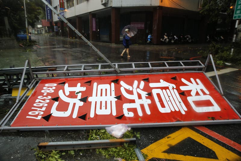 RIT09 HUALIEN (TAIWÁN) 27/09/2016.- Un hombre camina junto a motos tiradas en el suelo bajo la lluvia debido a los fuertes vientos por la llegada del Tifón Megi en el condado de Hualien en el este de Taiwán hoy, 27 de septiembre de 2016. China y la isla de Taiwán están en estado de alerta y han tomado medidas de prevención ante la llegada del tifón Megi, que podría llevar fuertes lluvias a sus costas, informaron hoy las respectivas autoridades. El ojo del tifón se encuentra a pocos kilómetros de la costa oriental de Taiwán. Se esperan lluvias de hasta 900 milímetros en varias partes de la isla, con el peligro de inundaciones y deslizamientos de tierra en especial en zonas montañosas. EFE/Ritchie B. Tongo