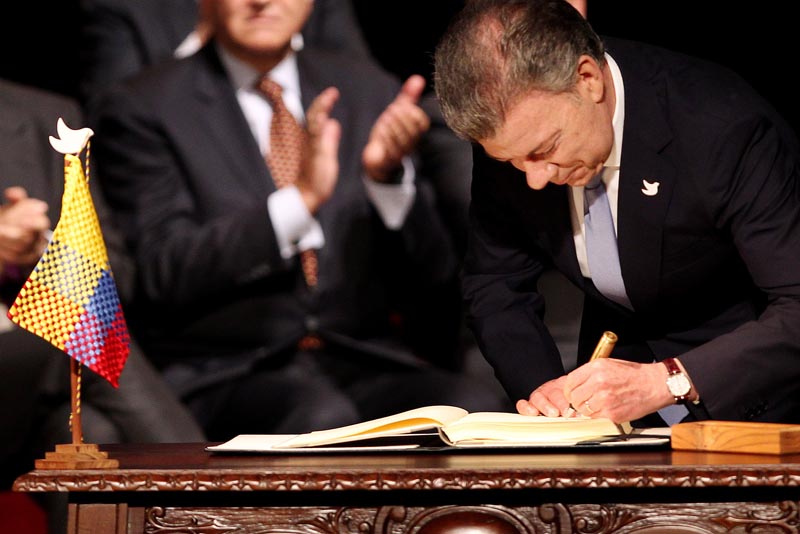 BOG107. BOGOTÁ (COLOMBIA), 24/11/2016.- El presidente de Colombia Juan Manuel Santos firma el nuevo acuerdo de paz para terminar 52 años de conflicto armado interno hoy, jueves 24 de noviembre de 2016, en Bogotá (Colombia). Santos y el jefe máximo de las FARC Rodrigo Londoño Echeverry "Timochenko" firmaron el acuerdo, que complementa el original del pasado 26 de septiembre en Cartagena de Indias, a las 11.30 hora local (16.30 GMT) en el Teatro Colón de Bogotá. Primero lo hizo el jefe guerrillero y luego el jefe de Estado, quienes utilizaron, al igual que en el primer acuerdo, un "balígrafo", bolígrafo fabricado con un casquillo de bala de fusil, que simboliza el tránsito de Colombia de la guerra a la paz. EFE/MAURICIO DUENAS CASTAÑEDA