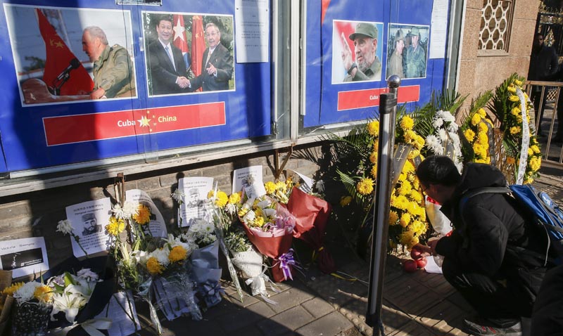 ROL03. Beijing (China), 28/11/2016.- A Chinese man offers apples amidst flowers and messages of condolences for the death of late Cuban leader Fidel Castro at the Embassy of Cuba in Beijing, China, 28 November 2016. Former Cuban President Fidel Castro died at the age of 90, in Cuba, on 25 November 2016. EFE/EPA/ROLEX DELA PENA