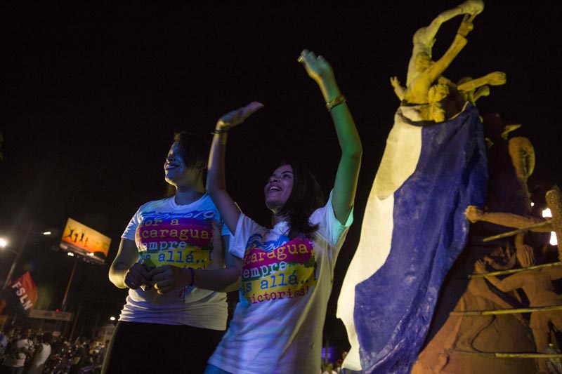 GRA004. MANAGUA (NICARAGUA), 07/11/2016.- El presidente de Nicaragua, Daniel Ortega, fue reelegido este domingo por tercera vez consecutiva con una amplia ventaja en unas elecciones sin observadores internacionales y cuyos resultados no serán reconocidos por el principal bloque opositor, que no participó en el proceso. En la imagen, dos mujeres participan de la celebracion de la ventaja del partido de gobierno en elecciones generales, hoy, 06 de noviembre de 2016, durante la finalizacion de los comicios electorales en Nicaragua. EFE/Jorge Torres