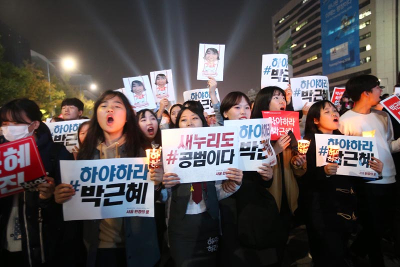 JHK09. Seoul (Republic Of), 05/11/2016.- South Koreans hold placards and candles as they march to protest against South Korean President Park Geun-Hye, in Seoul, South Korea, late 05 November 2016. The protesters gathered to demand South Korean President Park's resignation after she had issued a rare public apology on 04 November after acknowledging close ties to Choi Sun-sil, who is in the center of a corruption scandal. (Protestas, Seúl) EFE/EPA/JEON HEON-KYUN