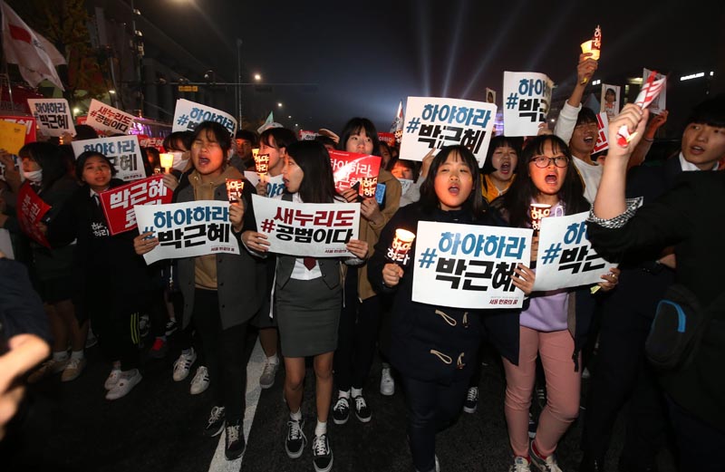 JHK07. Seoul (Republic Of), 05/11/2016.- South Koreans hold placards and candles as they march to protest against South Korean President Park Geun-Hye, in Seoul, South Korea, late 05 November 2016. The protesters gathered to demand South Korean President Park's resignation after she had issued a rare public apology on 04 November after acknowledging close ties to Choi Sun-sil, who is in the center of a corruption scandal. (Protestas, Seúl) EFE/EPA/JEON HEON-KYUN