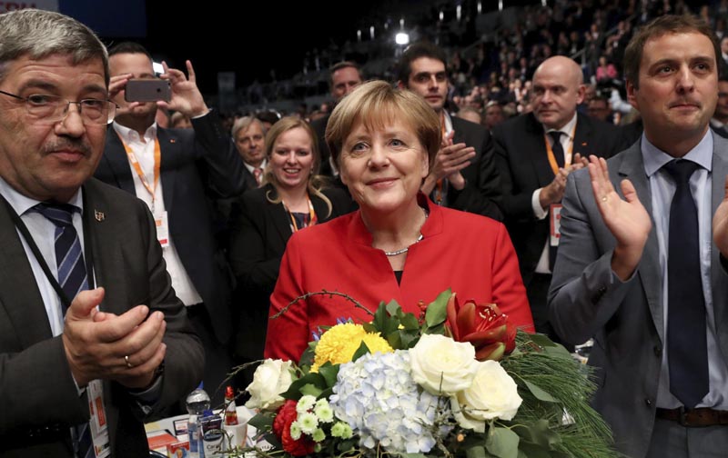 ESS63 ESSEN (ALEMANIA), 06/12/2016.- La canciller alemana, Angela Merkel (c), tras ser reelegida presidenta de la Unión Cristianodemócrata (CDU) con un 89,5 % de los votos, en el congreso federal que celebra la formación en Essen, Alemania, hoy, 6 de diciembre de 2016. Merkel obtuvo este resultado, frente al 96,7 % logrado dos años atrás, y fue ratificada así como líder del partido, dos semanas después de haber anunciado que optará a un cuarto mandato como canciller en los comicios previstos para dentro de diez meses. EFE/MICHAEL KAPPELER