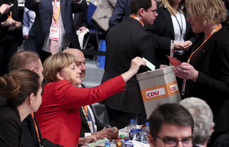 ESS63 ESSEN (ALEMANIA), 06/12/2016.- La canciller alemana, Angela Merkel (c), emite su voto durante el congreso federal de la Unión Cristianodemócrata (CDU), en Essen, Alemania, hoy, 6 de diciembre de 2016. Merkel advirtió hoy que no todos los refugiados llegados desde el año pasado al país podrán permanecer en Alemania, pero garantizó que se evaluará cada caso antes de adoptar una decisión al respecto. EFE/MICHAEL KAPPELER